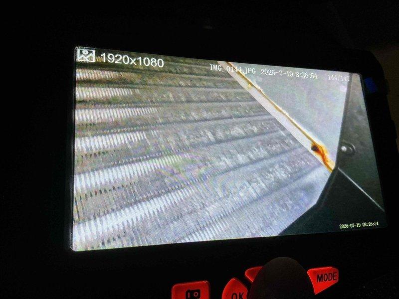 Completed scheduled cooling maintenance on residential air handler system. Performed inspection of evaporator coil using borescope camera to assess internal fin condition and checked refrigerant line connections. Documented equipment condition with photos showing U-bend copper coil configuration and insulated refrigerant lines in attic installation.