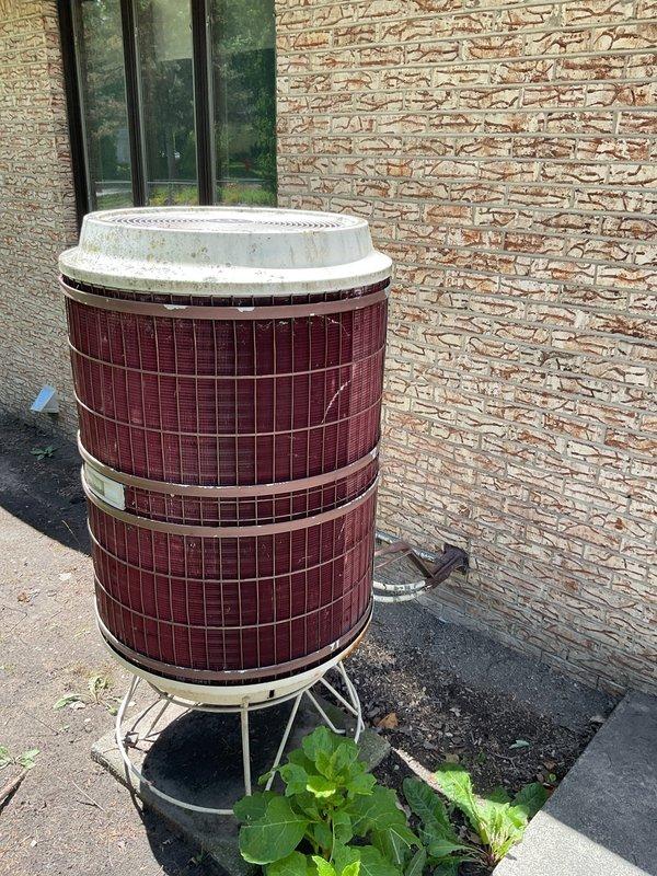 Conducted comprehensive assessment of existing Carrier air conditioning system for replacement estimate. Documented current equipment specifications from unit nameplate and photographed outdoor condenser unit positioned on concrete pad with burgundy cylindrical casing. Provided customer with detailed replacement options and pricing for new HVAC system installation.