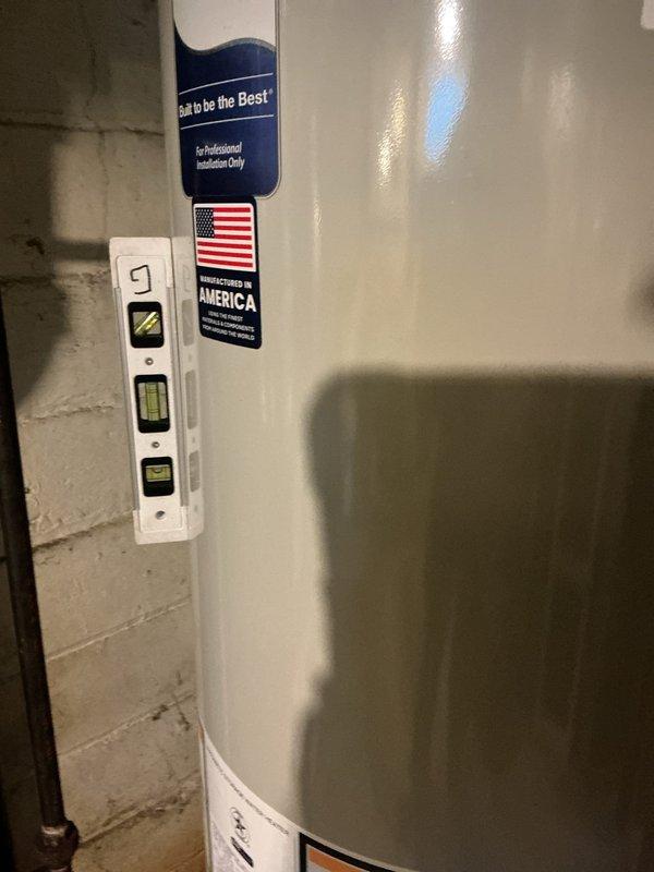 Responded to service call for water heater estimate. Upon arrival, assessed existing Bradford White tanked water heater installation in basement utility area. Inspected unit condition, venting system with metallic ductwork, copper supply line connections, brass shutoff valve, and pressure relief valve assembly. Photographed current installation showing unit positioned against concrete block wall with all plumbing connections and electrical wiring visible. Provided customer with replacement estimate options and discussed available water heater models meeting their needs.