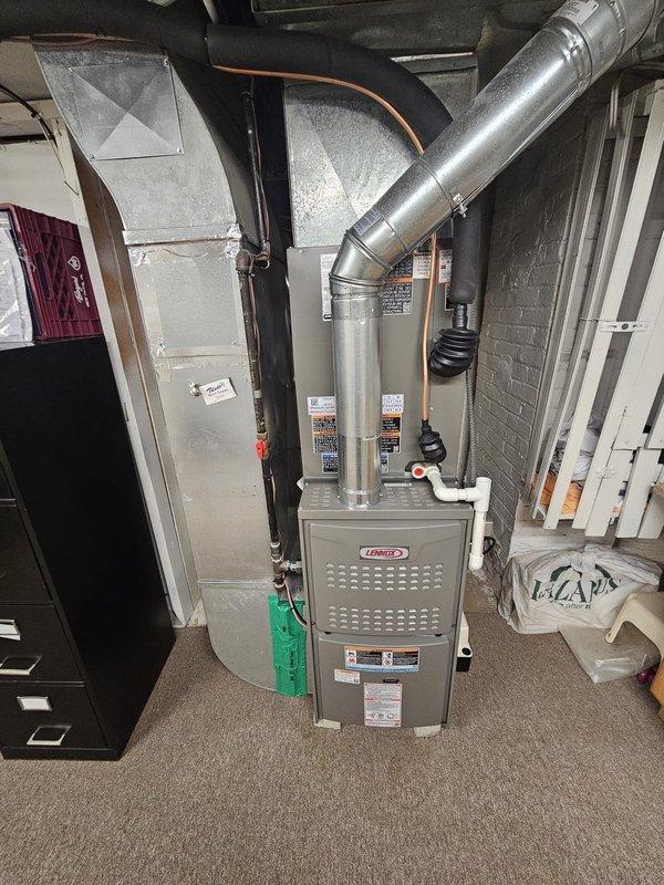 # HVAC Install - Complete System

Completed full residential HVAC system installation in basement utility area. Installed new Lennox furnace unit with complete ductwork configuration including metallic supply ducts and return air pathways. Routed and secured silver metallic ductwork with proper angles and connections from furnace plenum, incorporating vertical and horizontal runs throughout the space. Connected black insulated refrigerant lines and copper piping to system components, ensuring proper refrigerant flow between indoor and outdoor units.

Installed condensate drainage lines with appropriate pitch and routing to prevent water backup. Secured all ductwork connections with proper fasteners and sealed joints to prevent air leakage. Ran electrical connections to furnace and air handler components per manufacturer specifications and local electrical codes. Mounted all equipment to ensure proper clearances from walls, ceiling joists, and other utilities for service access and code