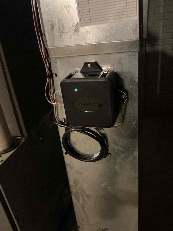 Completed annual preventive maintenance on a one-year-old residential air conditioning system. Inspected electrical components, capacitor, and wiring connections within the outdoor condensing unit, verified all connections were secure and properly terminated. Confirmed system monitoring device was operational with active status indicator and properly mounted to supply ductwork with all communication cables connected.