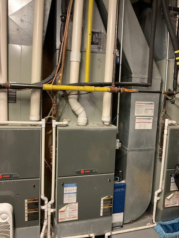 Completed comprehensive estimate for complete air conditioning system replacement at residential property. Assessed existing dual Trane HVAC system installation in mechanical room, including heating and cooling units, refrigerant line sets with insulation, gas piping infrastructure, PVC drainage system, electrical conduit connections, and ductwork plenum. Evaluated outdoor condensing unit positioned on concrete pad, noting equipment condition and accessibility for replacement. Provided detailed replacement recommendations and specifications for new AC system installation.
