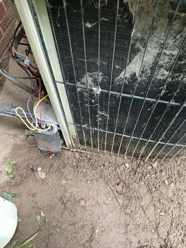 Responded to no cooling complaint on residential air conditioning system over 10 years old with indoor temperature not dropping below 83 degrees and compressor not running. Upon inspection, found outdoor condenser coil heavily obstructed with cottonwood seeds, dirt, and fibrous debris throughout the fins, severely restricting airflow and preventing proper heat rejection. Cleaned condenser coil, removed debris buildup, verified electrical connections, and restored system to normal operating condition with compressor running and proper cooling cycle established.