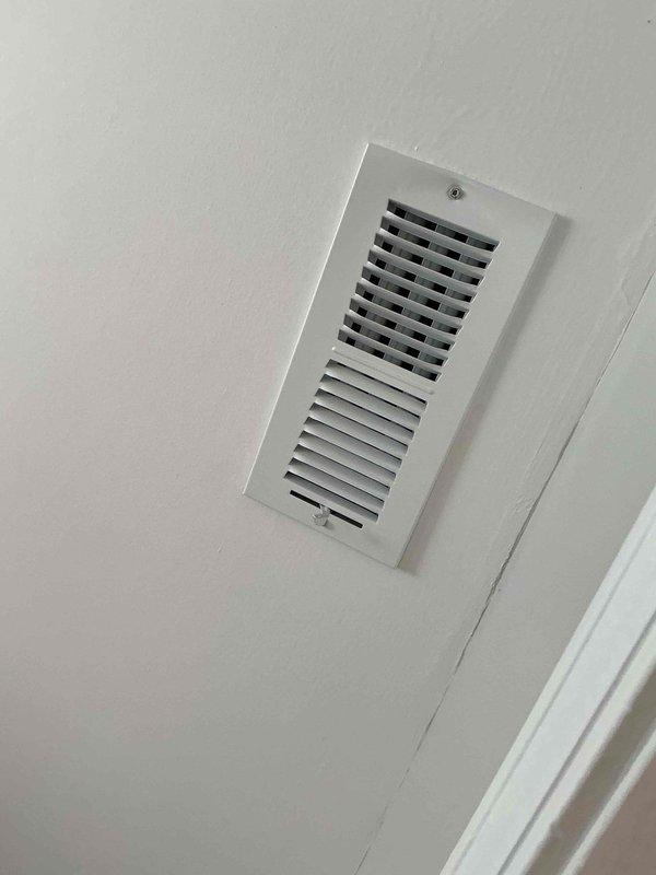 Responded to service call for aging furnace system with reported rattling noises occurring intermittently and inadequate air conditioning performance. Conducted thorough inspection of HVAC system components including furnace unit, ductwork, and air distribution system. Investigated attic area for source of unusual sounds and assessed ventilation concerns. Examined ceiling and wall-mounted supply vents for proper airflow and secure mounting. Documented system condition through photographic evidence showing air distribution registers and overall installation. Identified 10+ year old equipment requiring attention for noise issues and cooling deficiencies.