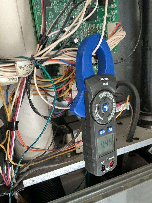 Completed preventative maintenance on air conditioning system over 10 years old. Inspected dual-run capacitor showing weathered condition with surface oxidation and rust present on mounting hardware; verified electrical specifications at 50+5 MFD 370VAC within acceptable parameters. Measured system amperage at 44.5 amps using clamp meter, confirming proper electrical operation. Cleaned condenser coil fins of accumulated dirt and debris, checked all electrical connections at control board, and verified proper wire terminations throughout unit.