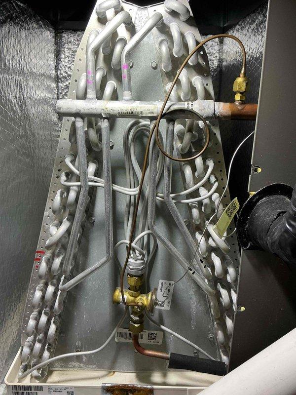 Completed comprehensive air conditioning tune-up on a 2-year-old residential HVAC system. Performed thorough inspection of evaporator coil assembly, verified proper refrigerant line connections and brass valve operation, checked all copper tubing for oxidation and integrity, and confirmed A-frame coil configuration was clean and functioning properly. All components tested within normal operating parameters with no immediate service needs identified.