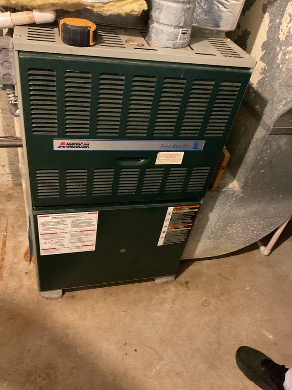 Conducted comprehensive evaluation of existing HVAC system for air conditioning replacement estimate. Assessed current equipment including American Standard Freedom 80 furnace located in basement utility area and outdoor condenser unit positioned on exterior concrete pad adjacent to residential structure. Documented existing system configuration, including ductwork connections, PVC drainage piping, and electrical service to both indoor and outdoor components. Photographed equipment specifications, model information, and installation details from manufacturer data plates. Evaluated outdoor unit placement, clearances from building structure and wooden fence, and condition of concrete pad foundation. Noted existing system layout to determine optimal replacement equipment sizing and compatibility with current infrastructure. Provided detailed estimate for complete air conditioning system replacement including removal of existing outdoor condenser unit and installation of new equipment.