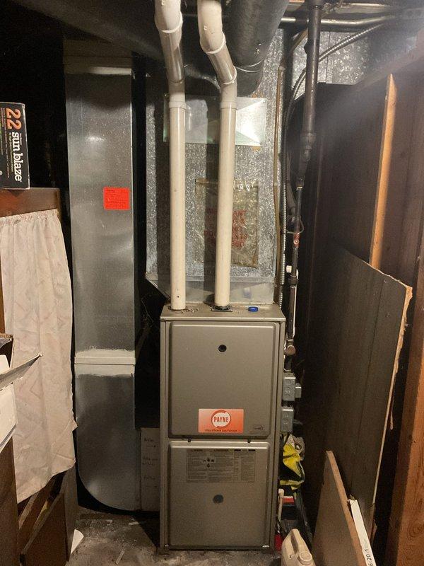 Conducted comprehensive assessment of existing HVAC system including basement-installed furnace and outdoor condensing unit to provide replacement estimate. Both units showed significant age and wear, with the outdoor condenser exhibiting substantial dirt accumulation, weathered surfaces, and debris buildup around the base. Documented current equipment specifications, photographed existing installations, and evaluated system configuration including venting, refrigerant line routing, and spatial constraints for replacement equipment recommendations.