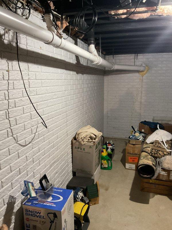 Conducted comprehensive site assessment of existing tanked water heater system in basement utility area to provide estimate for conversion to tankless water heater installation. Evaluated current plumbing infrastructure, including water supply lines, gas connections, venting requirements, and electrical systems necessary for tankless unit operation. Documented existing conditions of mechanical room, noting ceiling-mounted drainage and plumbing lines, exposed joists, ductwork, and available clearances for new equipment installation and code-compliant venting modifications.