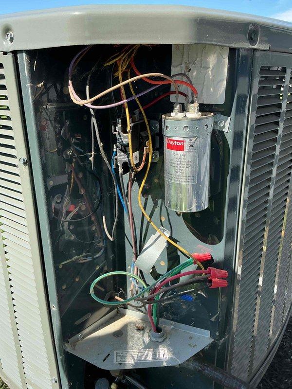 Responded to service call for noisy outdoor compressor unit on 7-year-old residential air conditioning system. Upon arrival, performed diagnostic inspection of the outdoor condensing unit and identified the issue as a failing capacitor. Removed access panel to inspect electrical components and confirmed the Dayton brand capacitor showed signs of deterioration and was causing abnormal operational noise. Replaced defective capacitor with properly rated OEM equivalent unit, secured all electrical connections, and verified proper wire routing. Tested system operation to ensure compressor started smoothly without noise, confirmed proper amperage draw, and verified cooling cycle functioned correctly. Reinstalled access panel and left system running normally.