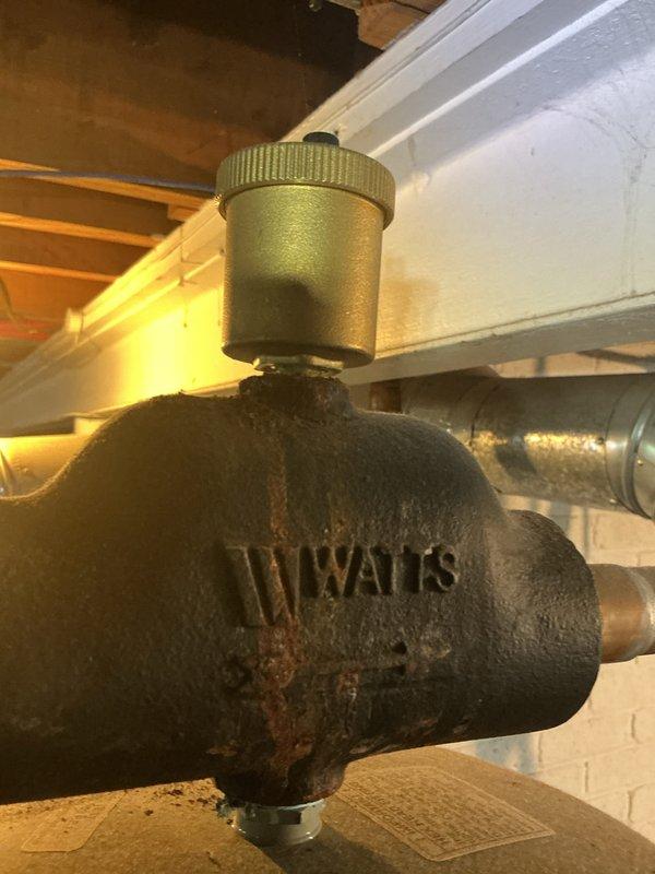 Completed comprehensive inspection of two boilers and two water heaters at the property. Examined all major components including valves, piping connections, air vents, and pressure relief systems. Assessed the condition of Watts brand valve assemblies, copper piping, and brass fittings, noting normal age-related patina and surface oxidation consistent with system operation. Evaluated upstairs thermostat and confirmed non-operational status requiring replacement or repair. Documented all findings with photographs showing plumbing connections, valve assemblies, and associated hardware in basement utility area. All boiler and water heater systems inspected for proper operation, safety compliance, and potential maintenance needs.