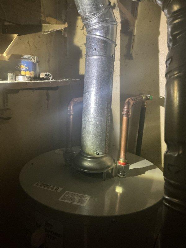 Installed a 30-gallon low-boy water heater to accommodate space restrictions in the utility area. Unit was positioned on a plywood base with drain pan for proper clearance and code compliance. Connected hot and cold water supply lines using copper piping with appropriate shutoff valves, installed exhaust venting through existing ductwork, and verified proper leveling and operational functionality. Additionally provided customer with separate quotes for bathtub mixing valve repair and toilet replacement.