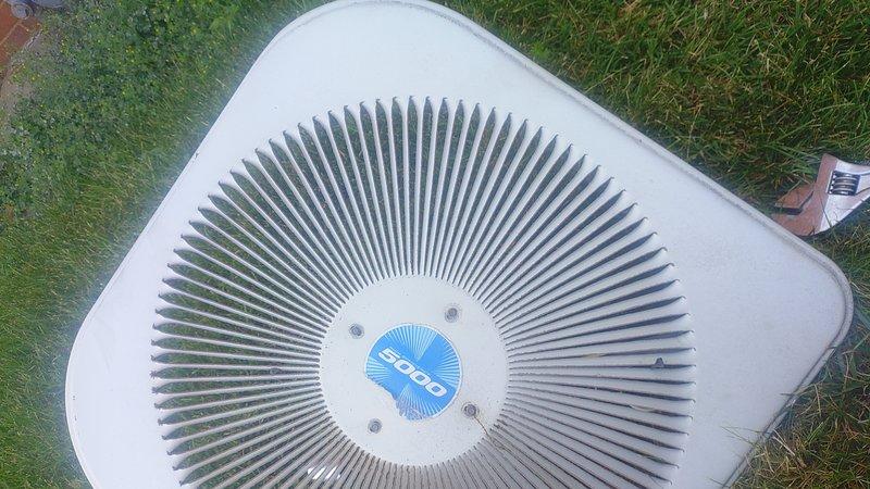 Replaced defective condenser fan motor on outdoor HVAC unit. Removed top cover to access internal components, disconnected electrical connections, and installed new motor assembly with fan blade. Verified proper operation and reassembled unit.