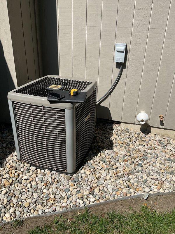 Conducted comprehensive on-site evaluation of existing HVAC system for replacement estimate. Assessed outdoor air conditioning unit positioned on gravel pad with existing electrical conduit and condensate drainage configuration. Inspected indoor furnace and water heater installation in basement mechanical room, noting current ductwork routing, PVC venting system, and equipment layout. Documented existing equipment specifications, clearances, and utility connections to develop accurate replacement proposal for both cooling and heating systems. Photographed current installation conditions including outdoor unit placement, indoor equipment positioning, existing duct connections, and available space for new equipment installation.