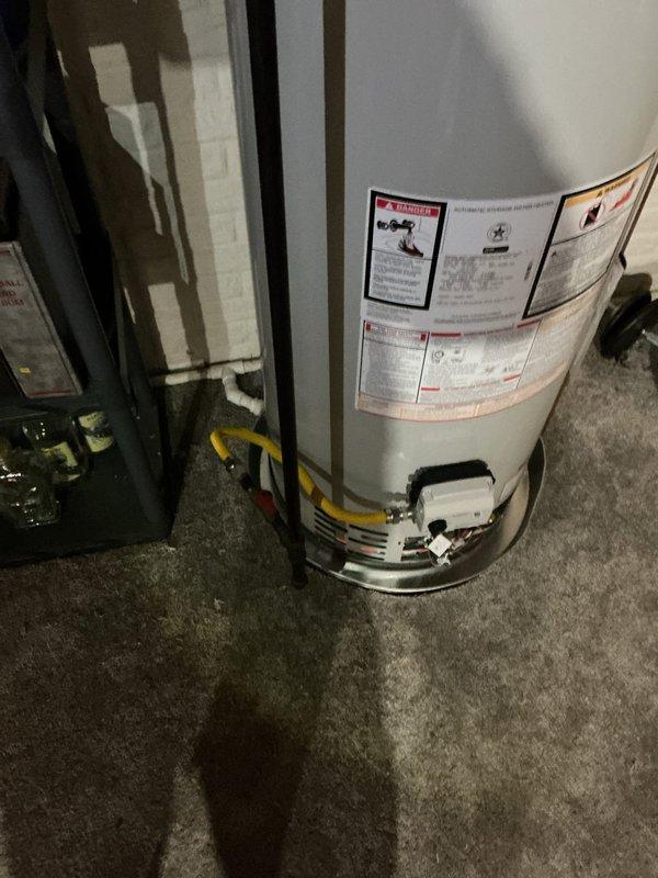 Installed a new 50-gallon residential tanked water heater in the utility area, connecting yellow gas supply lines and white PVC plumbing pipes according to manufacturer specifications and local code requirements. Verified proper level and plumb alignment of the unit and ensured all safety labels and warning stickers remained visible and intact upon completion.