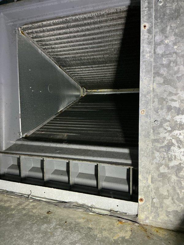 Completed preventive maintenance tune-up on 7-year-old air conditioning system located in attic space. Inspected A-frame evaporator coil assembly showing normal dust accumulation on fins, verified drain pan condition and proper drainage function, and examined pleated air filter which displayed typical particulate collection with adequate airflow capacity remaining. System operating within normal parameters upon completion of inspection.