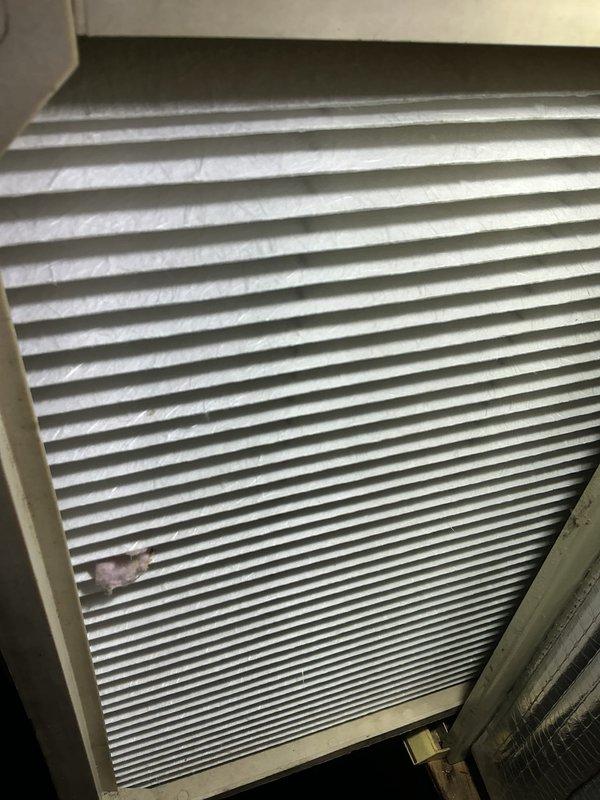 Completed preventive maintenance tune-up on 7-year-old air conditioning system located in attic space. Inspected A-frame evaporator coil assembly showing normal dust accumulation on fins, verified drain pan condition and proper drainage function, and examined pleated air filter which displayed typical particulate collection with adequate airflow capacity remaining. System operating within normal parameters upon completion of inspection.