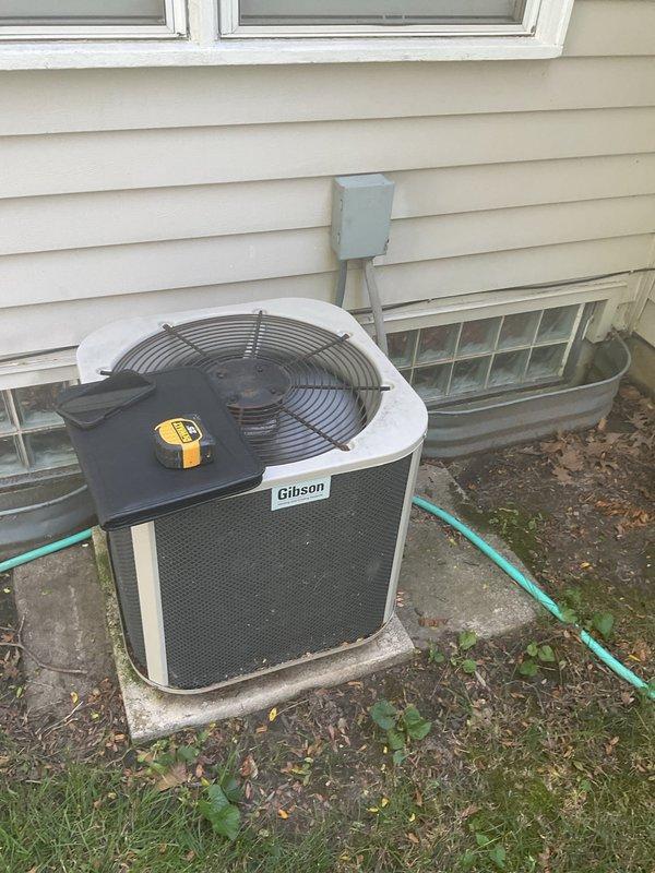 Conducted comprehensive site evaluation for complete HVAC system replacement at residential property. Assessed existing Gibson-branded outdoor condensing unit positioned on concrete pad adjacent to foundation, documenting current equipment condition, placement, and electrical disconnect configuration. Evaluated indoor air handler installation including existing ductwork connections, refrigerant line routing through insulated piping, condensate drainage system, and clearance requirements within mechanical space. Photographed both outdoor and indoor components to document system layout, access points, flexible duct connections, and metal trunk line configuration for accurate equipment sizing and replacement planning. Provided detailed estimate for new system installation including removal of existing equipment, proper disposal, and installation of replacement HVAC system meeting current efficiency standards and building code requirements.