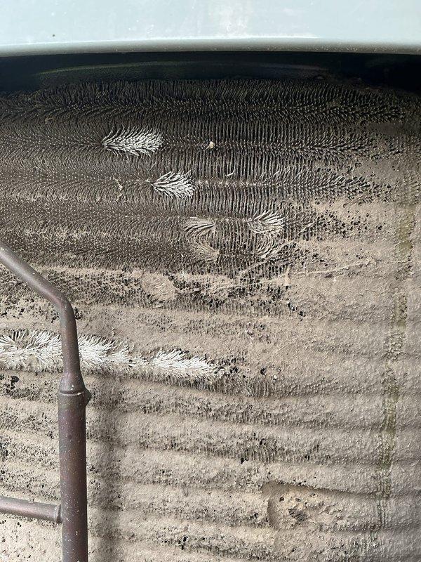 # HVAC Service Completed

Responded to no cooling complaint on 10-year-old residential air conditioning system. Upon inspection, discovered severely restricted airflow due to heavily contaminated evaporator coil with significant dust and debris accumulation throughout the fin surfaces. The coil exhibited extensive frost and ice formation across multiple sections, indicating restricted airflow was causing the coil to freeze during operation.

Found excessive ice buildup on refrigerant lines and ductwork near the air handler, confirming inadequate air circulation across the evaporator coil. The combination of heavy dirt accumulation and resulting ice formation had completely blocked airflow, preventing the system from delivering cool air to the living space.

Documented existing conditions with photographs showing the extent of contamination and frost damage. Recommended immediate coil cleaning and system evaluation to restore proper cooling operation and prevent compressor damage from c