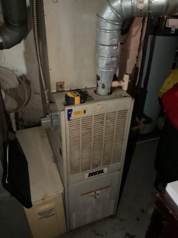 Completed comprehensive assessment of existing HVAC system for full replacement estimate. Evaluated indoor Heil furnace unit located in basement utility area and outdoor air conditioning condenser unit on exterior patio. Documented current equipment condition, including weathered outdoor condenser with visible rust staining and corrosion on metal housing, copper refrigerant lines, and existing ductwork configuration with galvanized steel trunk lines. Photographed equipment specifications, clearances, electrical connections, and installation parameters to provide accurate replacement system sizing and installation requirements for complete AC system upgrade.