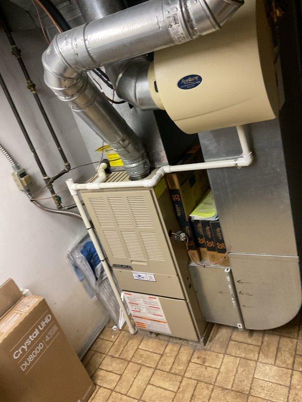 Conducted comprehensive assessment of existing HVAC system for complete replacement of both air conditioning and furnace units. Evaluated current equipment configuration in basement mechanical room, including existing furnace with connected ductwork and wall-mounted air handler components. Inspected outdoor condenser unit positioned on gravel pad against building exterior, noting electrical service connections and existing installation parameters. Documented equipment specifications, ductwork layout, electrical requirements, and site conditions through detailed photography to develop accurate replacement proposal. Provided estimate for new system installation including proper sizing calculations based on existing infrastructure and space requirements.