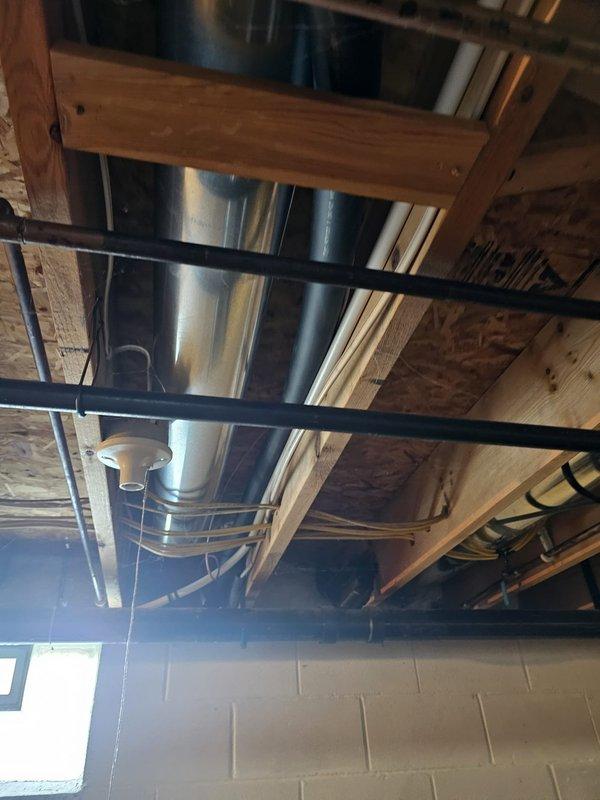 Completed full HVAC system installation featuring a 16.5 SEER, 3.5-ton Lennox split gas system with 96% efficiency 90kBtu upflow furnace and matching upflow coil. Installed new 7/8" x 50' refrigerant line set, 5" metal filter rack, exterior condenser pad, disconnect box with whip, and WiFi-enabled thermostat. Removed existing wall bracket and relocated condenser unit to new pad location, routing new PVC condensate and exhaust venting through exterior wall to ensure proper drainage and combustion air flow for high-efficiency furnace operation.