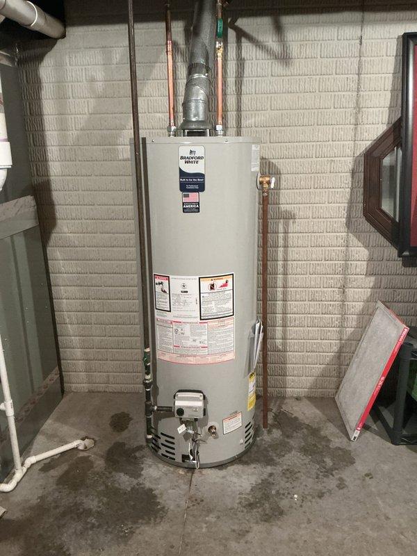 Replaced existing 50-gallon residential water heater with new Bradford White unit in basement utility room. Installation included connecting all water supply lines, gas line, and proper venting system, with condensate pump mounted for drainage management. All plumbing connections were secured with appropriate fittings and sealed to manufacturer specifications, and unit was tested for proper operation upon completion.