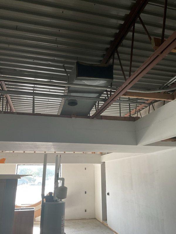 Completed comprehensive estimate for complete ductwork replacement system in commercial or light industrial facility. Assessed existing conditions and staged new galvanized steel rectangular ductwork components, transition fittings, and elbow joints for installation throughout the mechanical space. Evaluated ceiling-mounted distribution system with corrugated metal decking and structural steel framework to determine optimal routing and support requirements for new duct runs.