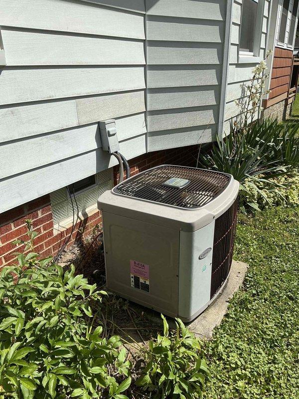 # HVAC Service Completed

Responded to service call for 15-year-old residential air conditioning system not producing cold air. Upon arrival, performed visual inspection of outdoor condenser unit located on concrete pad against exterior wall. Unit appeared to be original equipment with significant age-related wear.

Conducted comprehensive diagnostic evaluation of the system. Checked electrical connections at outdoor disconnect box and verified power supply to condenser. Measured refrigerant pressures and temperatures to assess system charge levels and compressor operation. Inspected condenser coil for blockages and airflow restrictions through protective grille and side louvers. Examined refrigerant line set with foam insulation running from condenser to interior air handler.

Identified multiple issues consistent with aging equipment: low refrigerant charge indicating potential leak in system, reduced compressor efficiency, and debris accumulation around condenser unit affecting heat