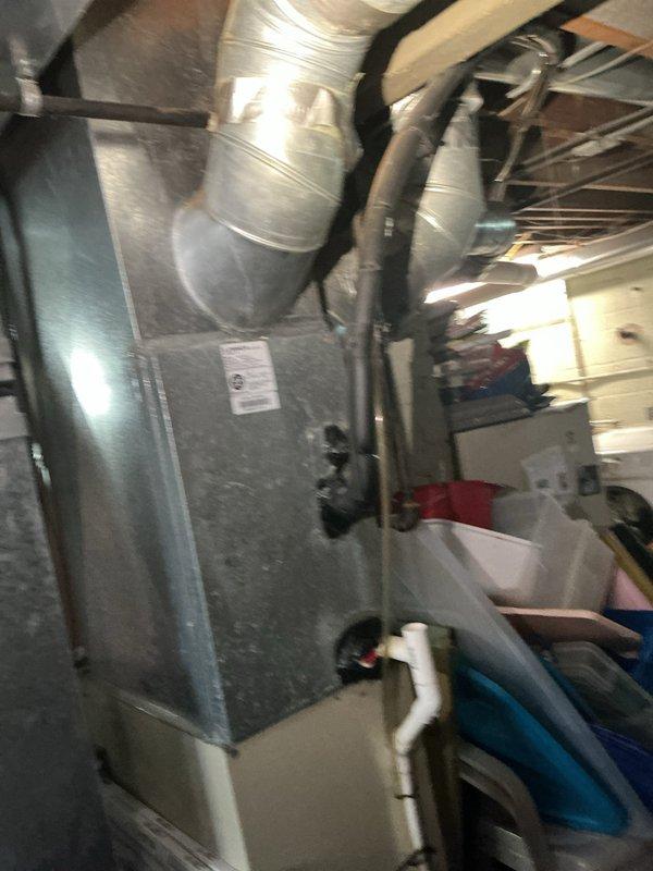 Responded to no cooling call affecting entire home with 30-year-old air conditioning system. Upon arrival, performed diagnostic assessment of indoor air handler unit and associated ductwork in basement mechanical room. Inspected furnace/air handler cabinet, verified proper electrical connections, and examined condensate drainage system including PVC piping. Evaluated condition of supply ductwork with reflective insulation wrapping and flexible connections. Documented existing equipment configuration showing significant age and wear consistent with three decades of operation. Given the advanced age of the system well beyond typical 15-20 year lifespan, provided recommendations for complete system replacement to restore cooling functionality and improve energy efficiency.
