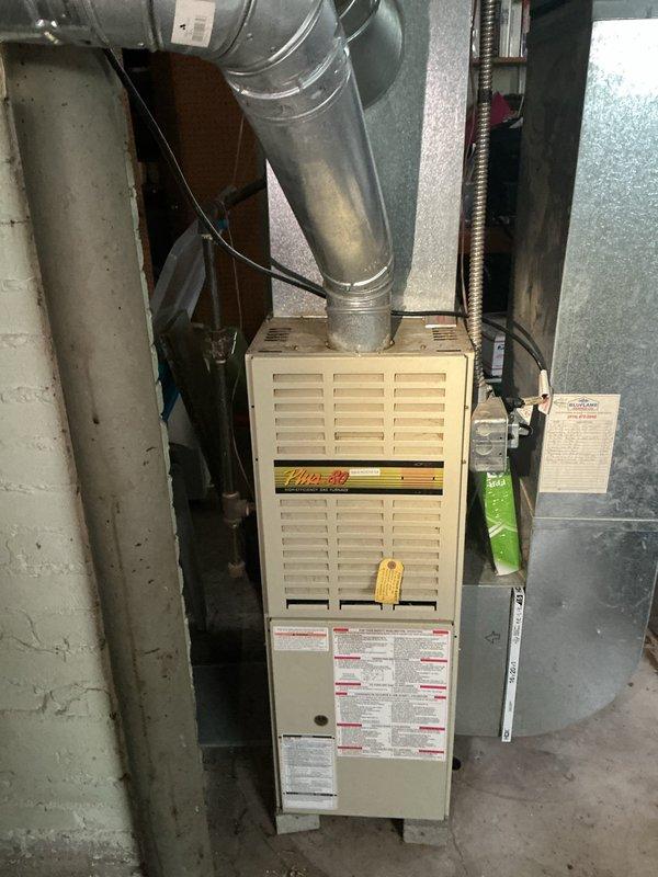Responded to no cooling call affecting entire home with 30-year-old air conditioning system. Upon arrival, performed diagnostic assessment of indoor air handler unit and associated ductwork in basement mechanical room. Inspected furnace/air handler cabinet, verified proper electrical connections, and examined condensate drainage system including PVC piping. Evaluated condition of supply ductwork with reflective insulation wrapping and flexible connections. Documented existing equipment configuration showing significant age and wear consistent with three decades of operation. Given the advanced age of the system well beyond typical 15-20 year lifespan, provided recommendations for complete system replacement to restore cooling functionality and improve energy efficiency.