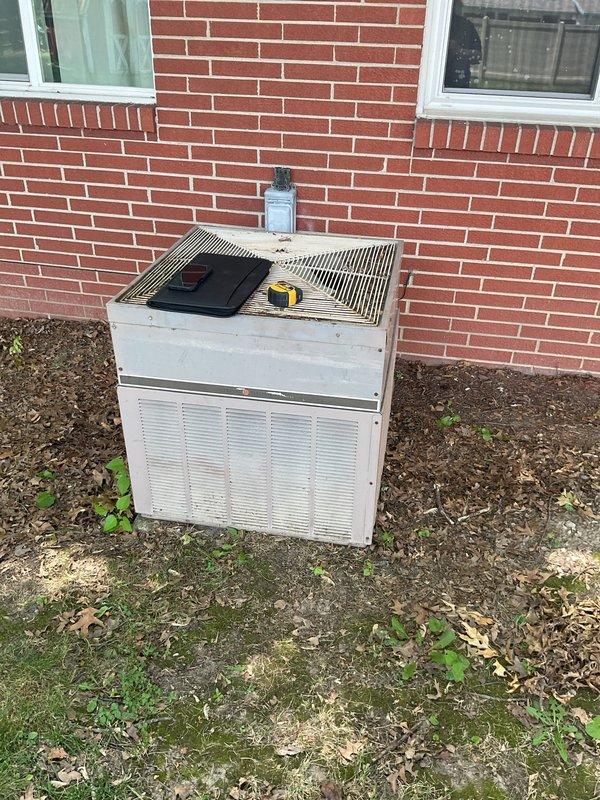 Conducted comprehensive evaluation of existing HVAC system for replacement estimate. Assessed outdoor condenser unit showing significant weathering and age-related deterioration, with unit positioned on grade against exterior brick wall. Documented indoor furnace and associated ductwork configuration in utility area. Captured detailed photographs of both outdoor and indoor equipment to support replacement proposal and system sizing calculations.