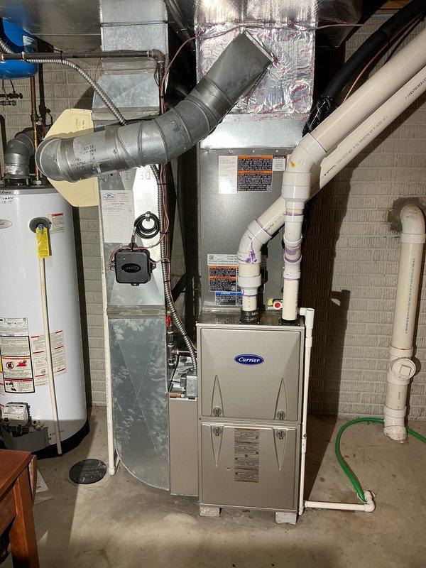 Completed installation of 3.5-ton single-stage air conditioning system with upflow cased coil in basement utility area. Installed B-width evaporator coil with metal spacer above existing furnace, ran new 7/8-inch lineset approximately 50 feet to outdoor condenser unit mounted on new equipment pad, and installed new disconnect box and whip for electrical connection. Replaced existing thermostat with new unit and verified proper system operation including refrigerant charge, airflow, and temperature differential across coil.