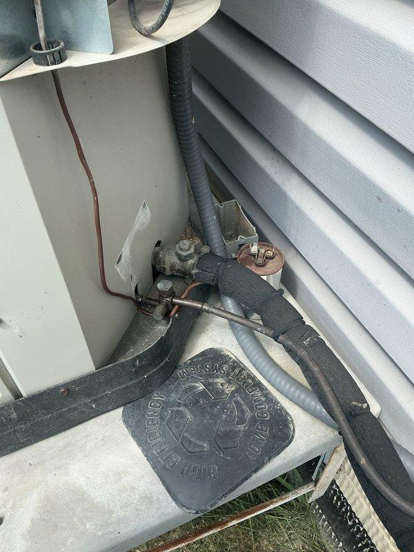 Responded to service call for 18-year-old residential air conditioning unit with reported fan operation but suspected compressor failure. Upon arrival, inspected outdoor condensing unit and associated refrigerant lines, electrical connections, and mounting pad. Confirmed abnormal operational sounds indicating compressor not engaging properly. Documented existing installation conditions including refrigerant line routing, condensate management components, and foundation-level utility connections for service records.