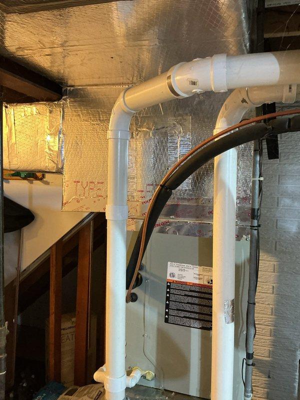 Responded to no cooling complaint on second floor with bedroom temperature at 84°F and minimal airflow from upstairs vents. Upon inspection, accessed attic space and mechanical room to evaluate air handler, ductwork configuration, and system operation. Documented HVAC equipment installation including air handler with refrigerant lines, PVC drainage system, and foil-faced insulation throughout attic area. Investigated suspected ductwork issues as reported concern, examining accessible duct runs and connections in attic space where supply distribution occurs for upper level zones. Photographed equipment and installation conditions for diagnostic reference. System appears to be original to 2012 construction with furnace filter recently replaced by homeowner prior to service call.