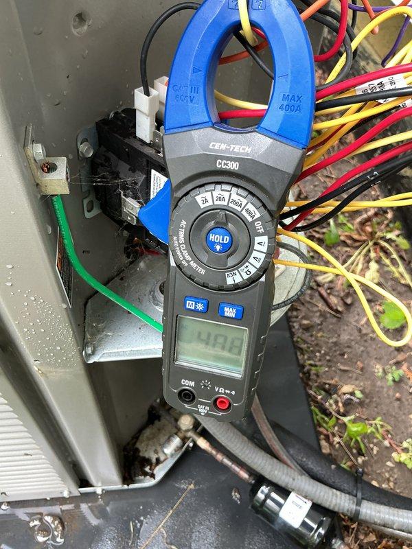 Responded to emergency no-cool call on two-year-old residential AC system. Upon arrival, performed electrical diagnostics on outdoor condensing unit using clamp meter, recording amperage reading of 48.1 amps at the contactor. Inspected condenser coil and found moderate accumulation of dirt, dust, and debris between aluminum fins, which was restricting proper airflow and reducing heat transfer efficiency. Assessed overall unit condition and identified maintenance needs. System restored to proper operation following service procedures.