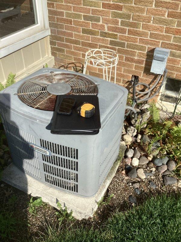 Completed comprehensive assessment of existing 2-ton split system air conditioning unit and furnace for replacement estimate. Outdoor condenser unit evaluated on concrete pad adjacent to structure, noting current equipment specifications, physical condition, and installation configuration including electrical disconnect and clearances. Indoor gas furnace inspected in basement mechanical room, documenting existing ductwork connections, gas line routing, copper refrigerant lines, and condensate drainage setup. Photographed both indoor and outdoor components to provide detailed documentation of current system layout, equipment access points, and site conditions for accurate replacement proposal development.