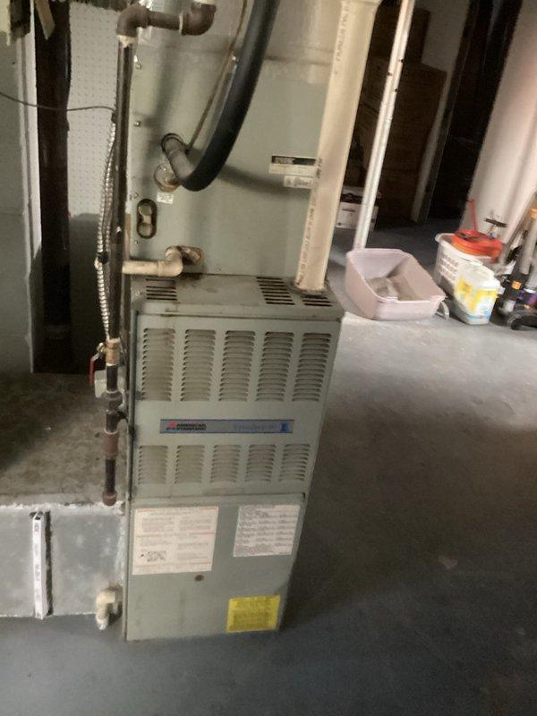 Completed comprehensive assessment of existing 2-ton split system air conditioning unit and furnace for replacement estimate. Outdoor condenser unit evaluated on concrete pad adjacent to structure, noting current equipment specifications, physical condition, and installation configuration including electrical disconnect and clearances. Indoor gas furnace inspected in basement mechanical room, documenting existing ductwork connections, gas line routing, copper refrigerant lines, and condensate drainage setup. Photographed both indoor and outdoor components to provide detailed documentation of current system layout, equipment access points, and site conditions for accurate replacement proposal development.