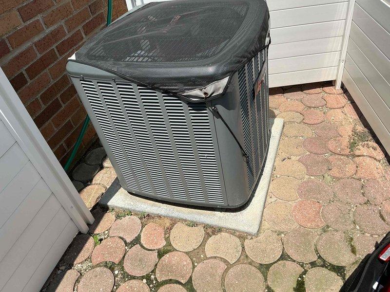 Completed preventive maintenance on 7-year-old residential air conditioning system. Removed access panel to inspect electrical components, tested capacitor and motor assembly functionality using diagnostic meter, verified proper wire connections and color-coded wiring integrity throughout the unit. Exterior condenser unit operating normally with adequate clearance from building structure and proper positioning on concrete pad.