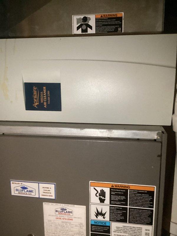 Completed comprehensive estimate for full HVAC system replacement including both furnace and air conditioning unit. Assessed existing outdoor Lennox AC unit mounted against exterior wall with refrigerant lines, electrical disconnect, and gas meter connections, noting established installation with vegetation growth around equipment. Evaluated indoor equipment consisting of stacked white Appliance brand air handler and gray/beige BluFlame furnace unit in mechanical room. Documented current system configuration, photographed all equipment and connections, and provided replacement recommendations for complete heating and cooling system upgrade.