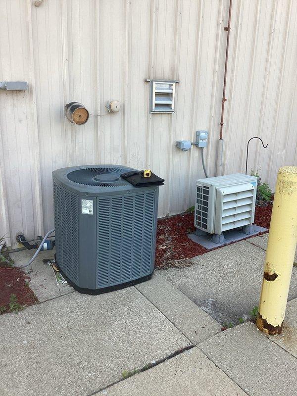 Completed comprehensive equipment estimate for full commercial HVAC system replacement, evaluating existing residential-grade furnace in basement utility area and outdoor condenser units. Documented current system configuration including gray metal furnace with PVC exhaust venting, black flexible ductwork, and dual outdoor units positioned on concrete pavers against building exterior. Coordinated with management regarding previous repair work and confirmed availability of parts credit toward new installation.