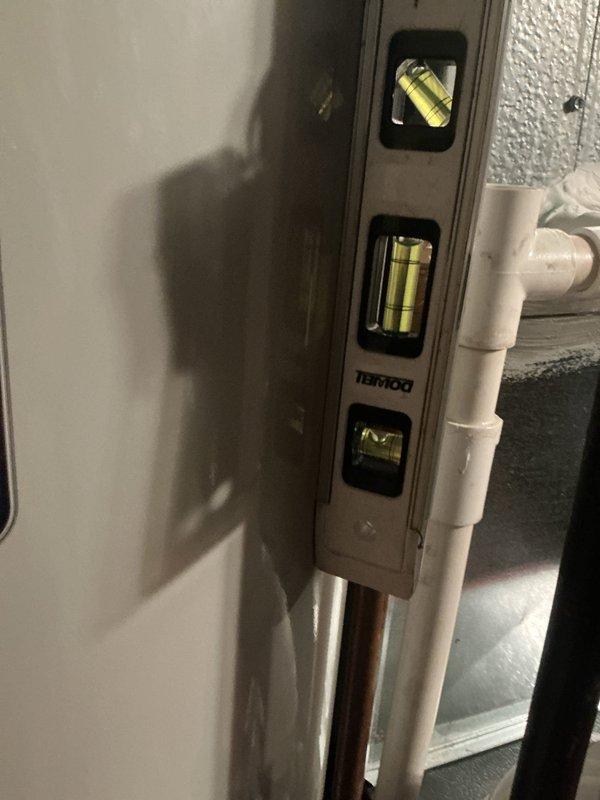 Completed installation of Bradford White tanked water heater in residential basement utility room. Connected all required plumbing components including copper supply lines and PVC piping, installed galvanized metal exhaust venting with proper elbow configuration, and verified level placement of unit. All connections tested and system confirmed operational.