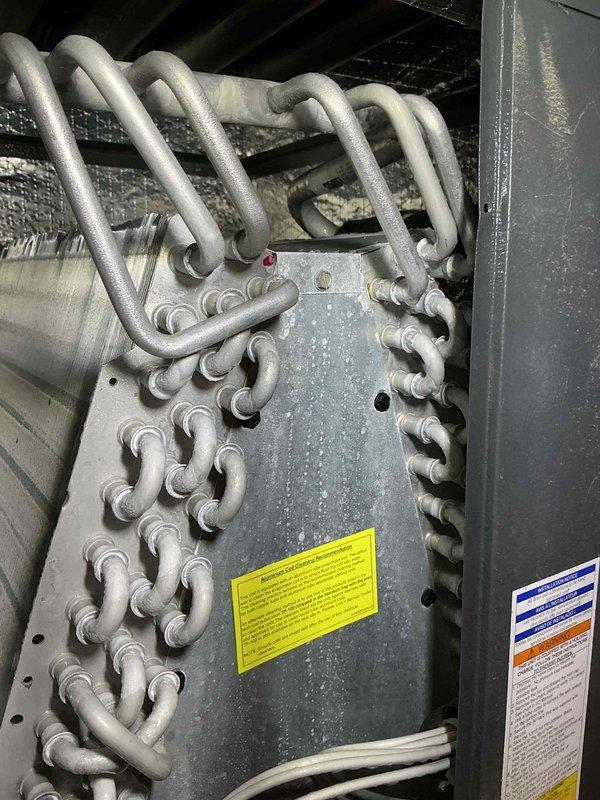 Performed annual maintenance on 6-year-old split system air conditioning unit. Inspected indoor air handler, refrigerant lines, and heat exchanger coil assembly; verified all components operating within normal parameters with no issues detected. Documented equipment condition with photos showing clean heat exchanger tubing and properly connected refrigerant lines.