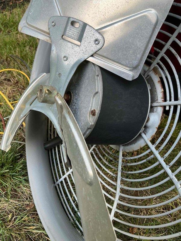 Performed comprehensive tune-up on 19-year-old air conditioning system. Disassembled and inspected condenser fan motor assembly, cleaned protective wire guards and housing components, and verified proper operation of the cylindrical outdoor condenser unit with beige casing and white protective grille.