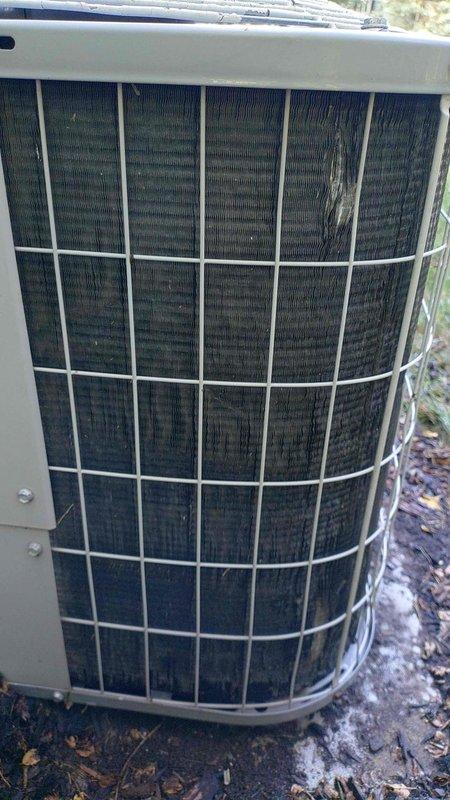 Performed comprehensive tune-up on 19-year-old air conditioning system. Disassembled and inspected condenser fan motor assembly, cleaned protective wire guards and housing components, and verified proper operation of the cylindrical outdoor condenser unit with beige casing and white protective grille.