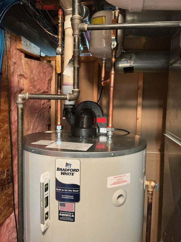 Installed a 75-gallon Bradford White power vent water heater in the basement utility area. Connected all supply and discharge piping, including copper water lines and pressure relief valve, ensuring proper integration with the existing plumbing system. Mounted the power vent blower assembly to the unit and verified all connections for safe operation.