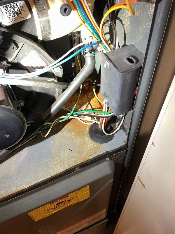 Responded to service call for malfunctioning thermostat. Customer had replacement thermostat on-site requiring installation and wiring. Successfully connected and installed customer-provided thermostat to existing HVAC system. Verified all wire connections at air handler, ensured proper communication between thermostat and equipment, and confirmed air conditioning system operational. Inspected condensate drain pan during service and noted moderate rust accumulation and mineral deposits indicating normal aging but functional condition. System tested and left in proper working order with thermostat controlling cooling functions as designed.