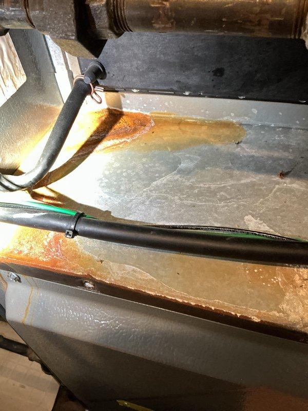 Responded to service call for malfunctioning thermostat. Customer had replacement thermostat on-site requiring installation and wiring. Successfully connected and installed customer-provided thermostat to existing HVAC system. Verified all wire connections at air handler, ensured proper communication between thermostat and equipment, and confirmed air conditioning system operational. Inspected condensate drain pan during service and noted moderate rust accumulation and mineral deposits indicating normal aging but functional condition. System tested and left in proper working order with thermostat controlling cooling functions as designed.
