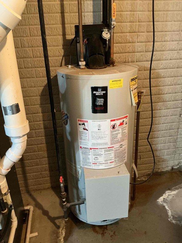 Responded to service call for aging water heater with active leak. Upon arrival, performed thorough assessment of existing Bradford White tank-style water heater unit installed in basement utility area. Confirmed visible signs of water damage on concrete floor surrounding base of unit, indicating active leak from tank. Evaluated overall condition of water heater, noting age-related deterioration and compromised tank integrity beyond economical repair.

Documented existing installation configuration, including copper supply line connections, shut-off valve locations, and current venting system. Photographed unit specifications, warning labels, and energy guide information for reference. Assessed proper clearances, base platform condition, and surrounding plumbing infrastructure. Reviewed electrical and gas connections to determine compatibility requirements for replacement unit.

Provided customer with professional estimate for complete water heater replacement, including removal and di