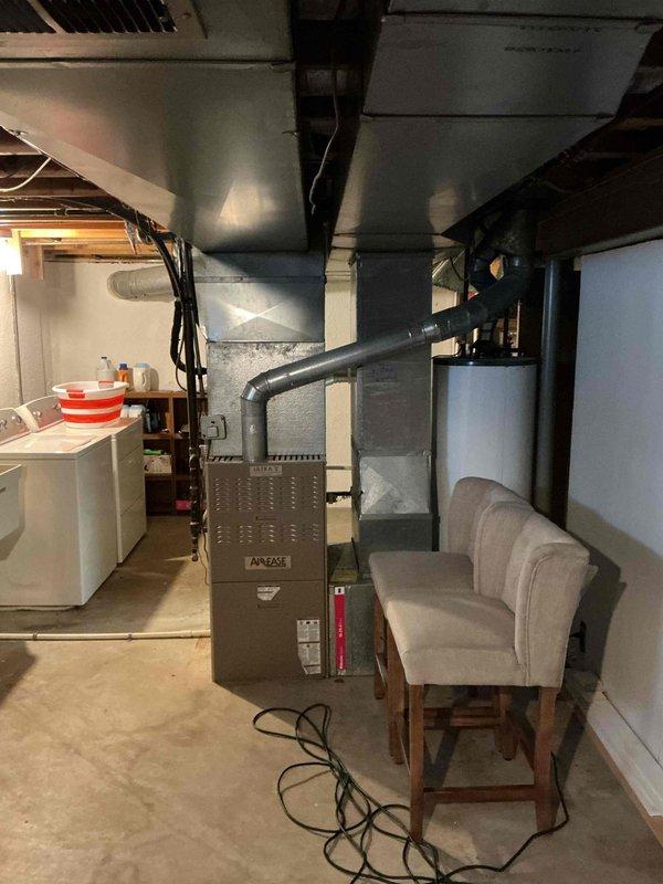 Responded to no cooling complaint on 26-year-old air conditioning system with both indoor and outdoor fans running but no cold air output and intermittent buzzing noise from outdoor unit. Upon inspection, diagnosed failed dual-run capacitor on outdoor condensing unit. Replaced defective TITAN PRO capacitor with properly rated replacement, restoring compressor operation. Verified system startup, confirmed proper amperage draw on compressor and condenser fan motor, and tested cooling performance. System now operating within normal parameters with cold air delivery restored throughout home.